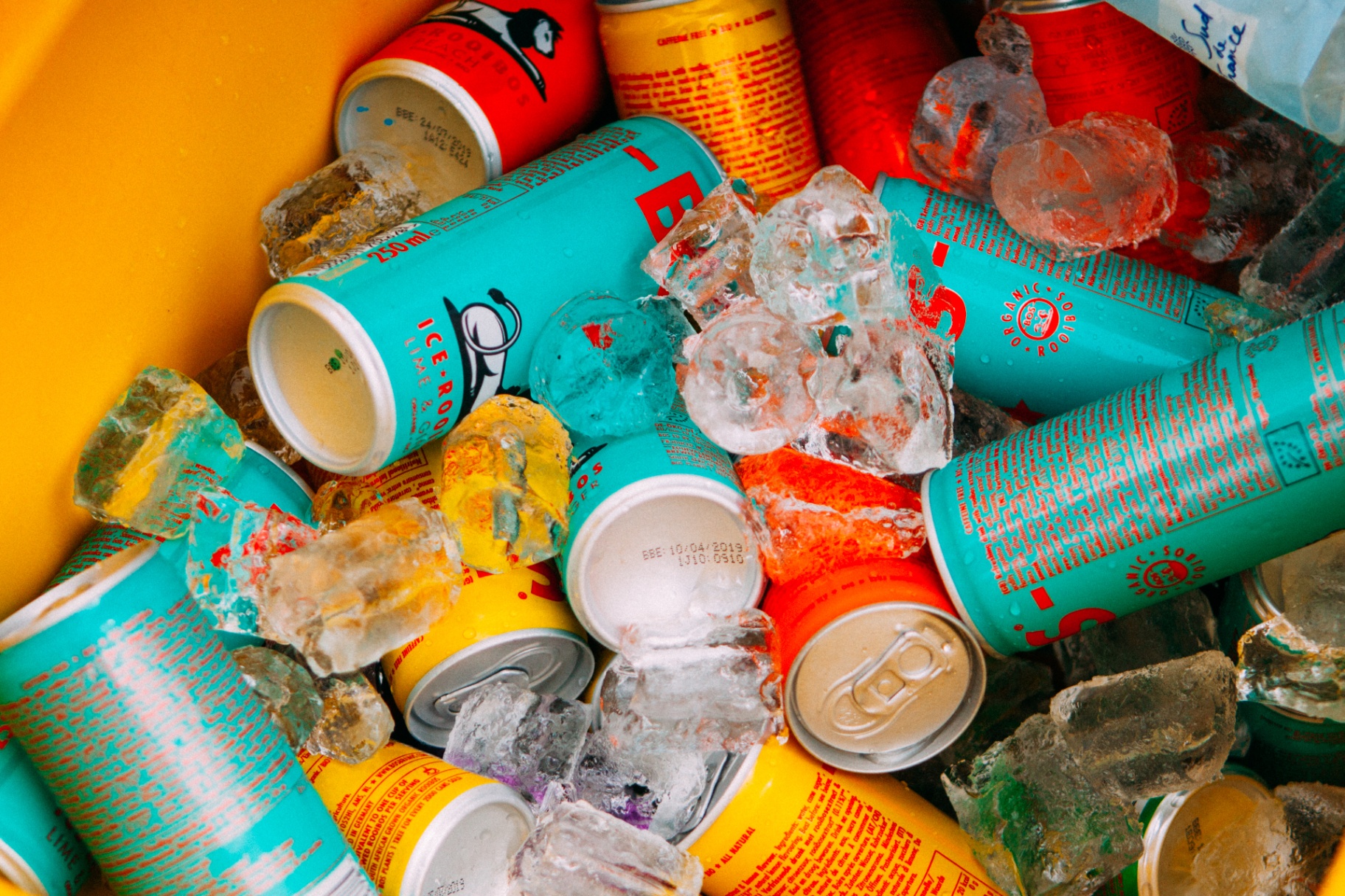 BOS rooibos ice tea cans packed in ice inside a bright yellow BOS bucket